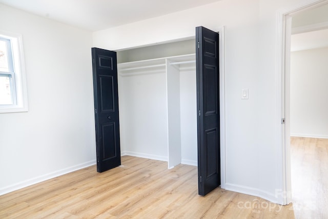 unfurnished bedroom with light hardwood / wood-style floors and a closet