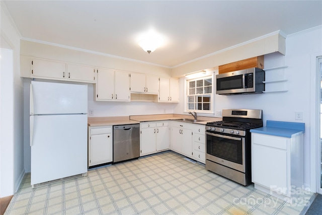 kitchen with ornamental molding, appliances with stainless steel finishes, sink, and white cabinets