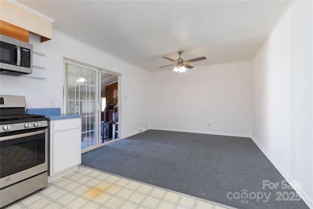 kitchen with crown molding, appliances with stainless steel finishes, light colored carpet, and ceiling fan