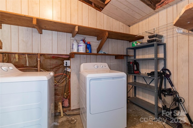 washroom with wooden walls and separate washer and dryer