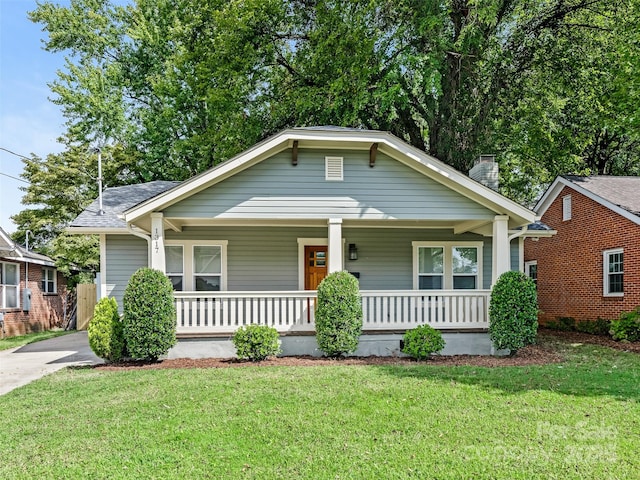 bungalow featuring covered porch and a front lawn