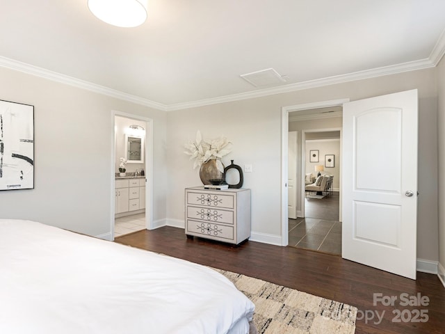 bedroom with dark wood-type flooring, ornamental molding, and ensuite bath