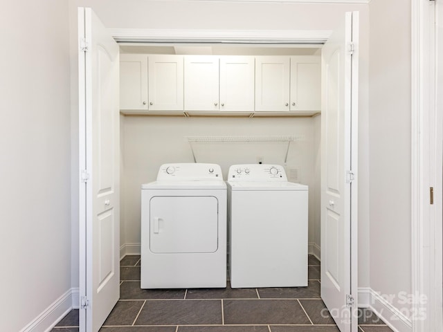 clothes washing area featuring washer and dryer and cabinets