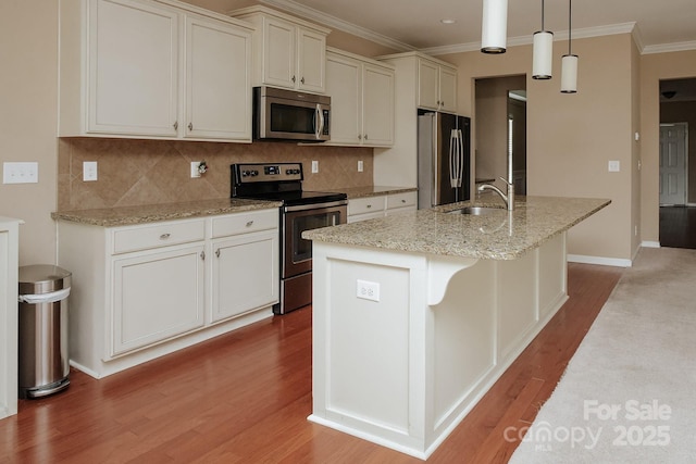 kitchen with sink, stainless steel appliances, light stone counters, an island with sink, and pendant lighting