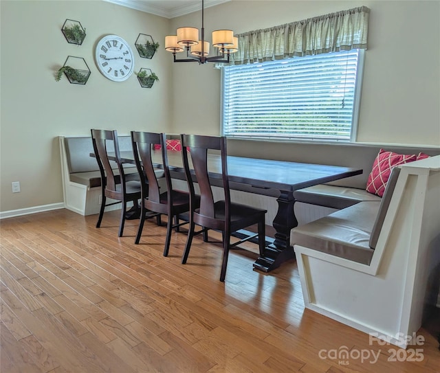 dining space featuring wood-type flooring, an inviting chandelier, and crown molding