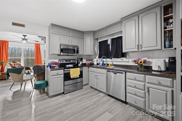 kitchen featuring gray cabinetry, ceiling fan, sink, and stainless steel appliances