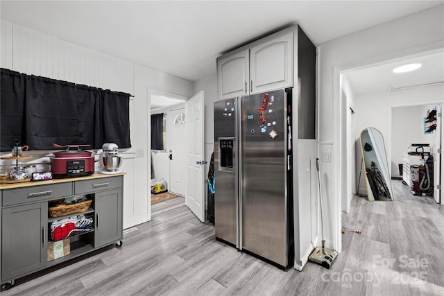 kitchen with gray cabinetry, stainless steel fridge with ice dispenser, and light wood-type flooring