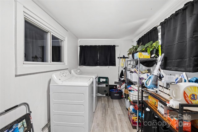 washroom with washing machine and dryer, wooden walls, light hardwood / wood-style flooring, and ornamental molding