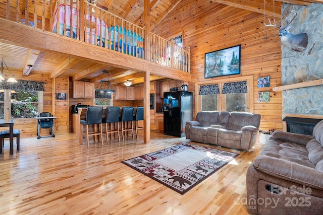 living area featuring wooden ceiling, wooden walls, and light wood-style flooring