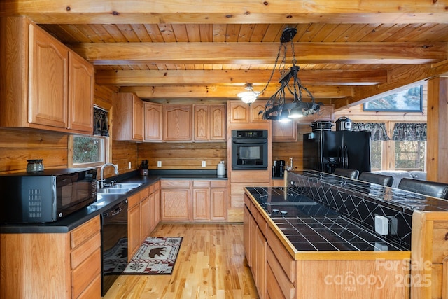 kitchen with beam ceiling, black appliances, a sink, tile countertops, and light wood-style floors