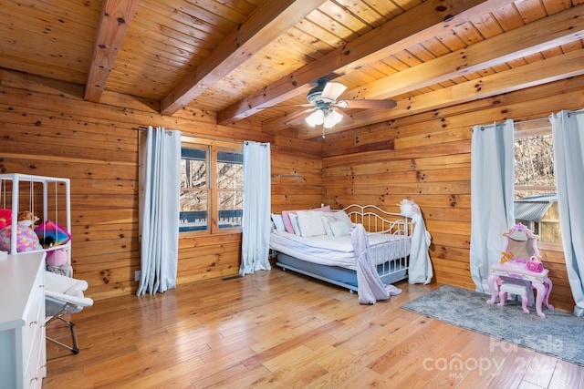 bedroom featuring wooden ceiling, wood finished floors, wood walls, and beam ceiling