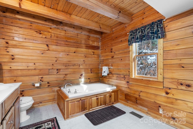 bathroom with vanity, wooden walls, a garden tub, beamed ceiling, and toilet