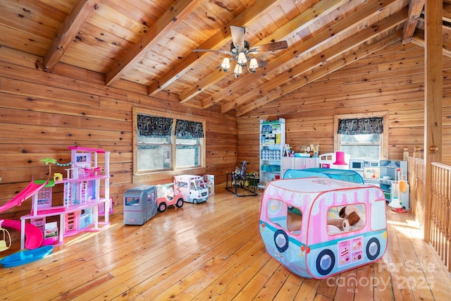 rec room featuring wooden walls, a ceiling fan, vaulted ceiling with beams, wood-type flooring, and wooden ceiling