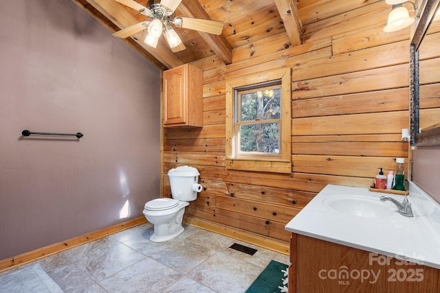 bathroom with vanity, vaulted ceiling with beams, wood ceiling, wood walls, and toilet