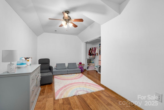 living area featuring ceiling fan, vaulted ceiling, and light wood finished floors