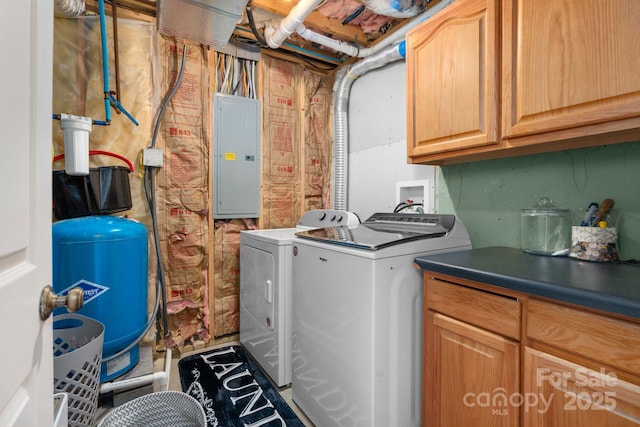 clothes washing area featuring electric panel, cabinet space, and washing machine and clothes dryer