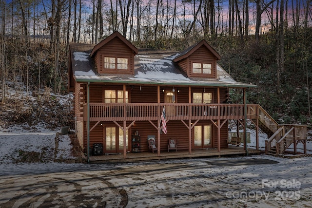 view of front of property featuring a deck, log siding, and french doors