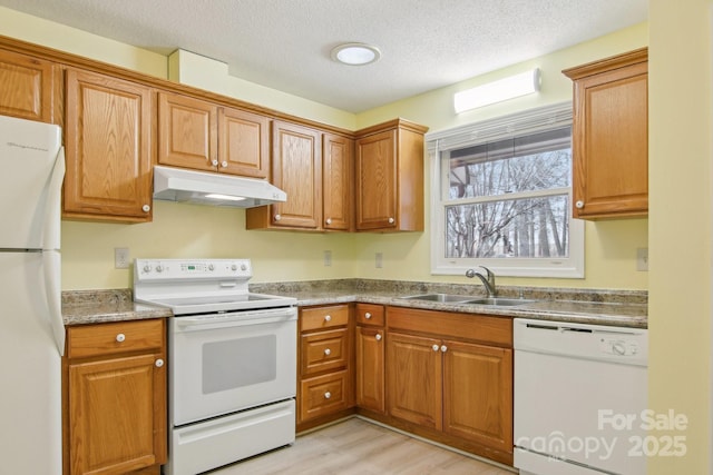 kitchen with a textured ceiling, light hardwood / wood-style floors, white appliances, and sink