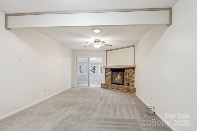 unfurnished living room featuring a textured ceiling, ceiling fan, carpet floors, and a fireplace