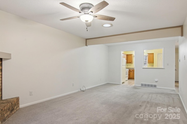 unfurnished living room featuring light carpet and ceiling fan