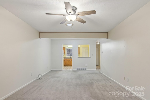 unfurnished room with light carpet, a textured ceiling, and ceiling fan