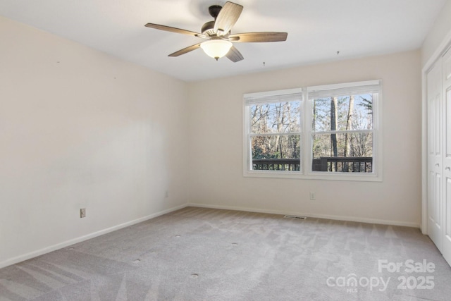 carpeted empty room featuring ceiling fan