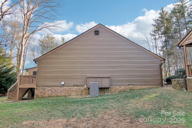 view of side of home with a yard and central air condition unit