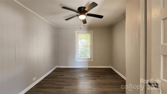 empty room with ceiling fan, dark hardwood / wood-style flooring, a textured ceiling, and ornamental molding