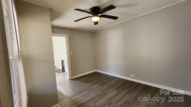 spare room with ceiling fan, dark hardwood / wood-style flooring, a textured ceiling, and ornamental molding