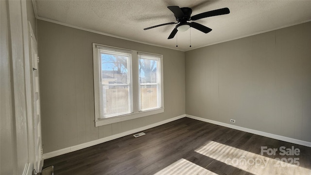 empty room featuring a textured ceiling, ceiling fan, ornamental molding, and dark wood-type flooring