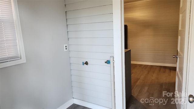 bathroom with hardwood / wood-style floors and wooden walls