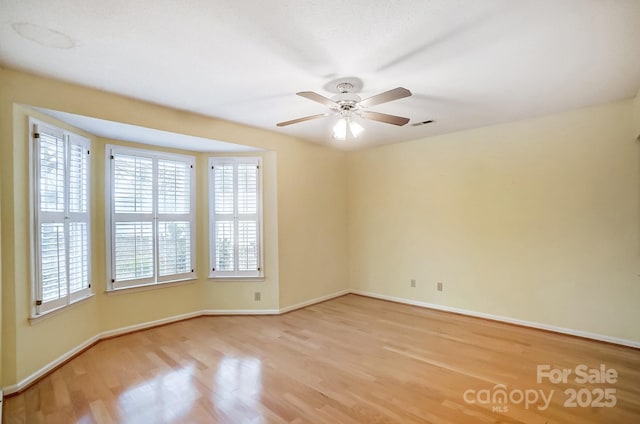 empty room with ceiling fan and light hardwood / wood-style floors