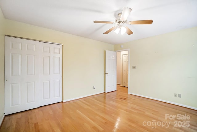 unfurnished bedroom featuring ceiling fan, a closet, and wood-type flooring