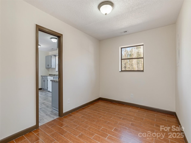 unfurnished room with a textured ceiling