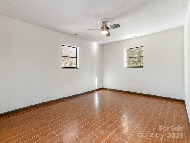 spare room with a textured ceiling and ceiling fan