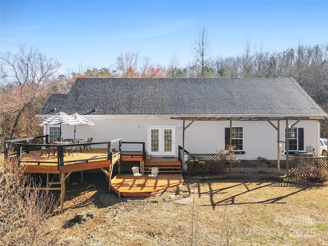 rear view of property with a shingled roof, french doors, and a deck