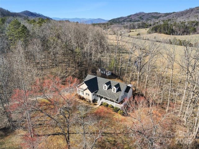 drone / aerial view featuring a mountain view and a view of trees