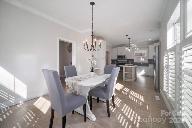 tiled dining area with crown molding, baseboards, and an inviting chandelier