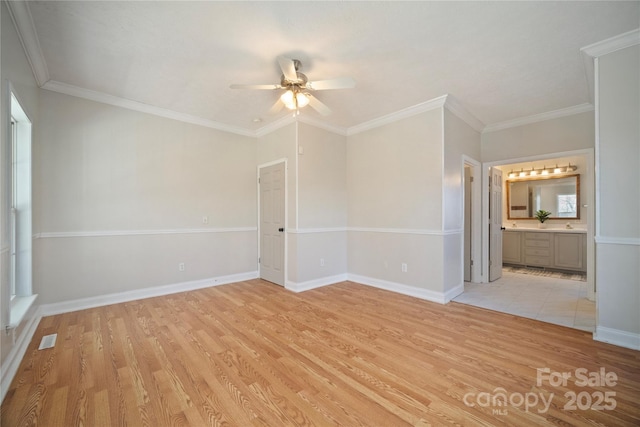 spare room with baseboards, visible vents, ceiling fan, ornamental molding, and light wood-type flooring