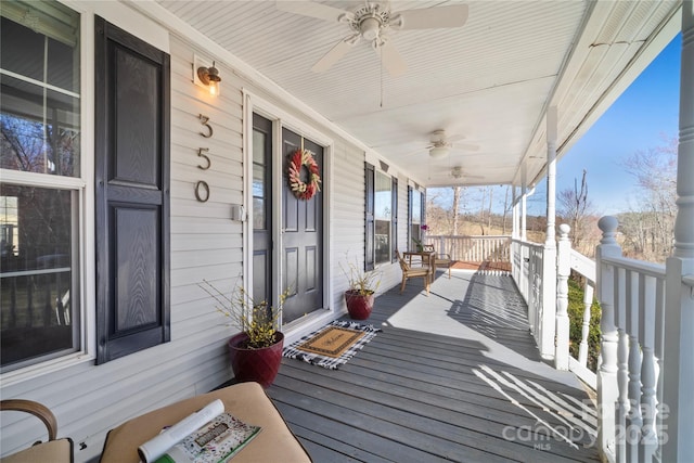 wooden deck featuring covered porch and a ceiling fan