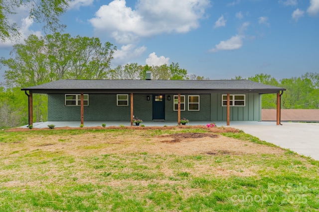 ranch-style house with board and batten siding, concrete driveway, an attached carport, and brick siding