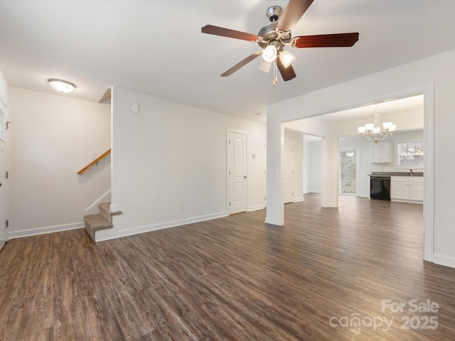 unfurnished living room with ceiling fan with notable chandelier and dark hardwood / wood-style flooring