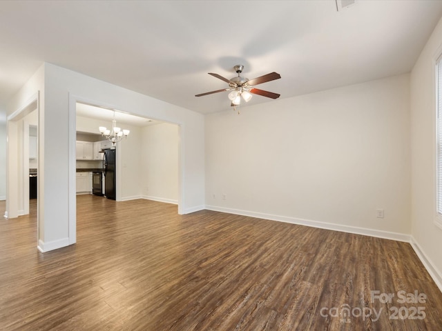 unfurnished living room featuring ceiling fan with notable chandelier and dark wood-type flooring