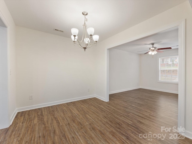 spare room featuring ceiling fan with notable chandelier and dark hardwood / wood-style floors