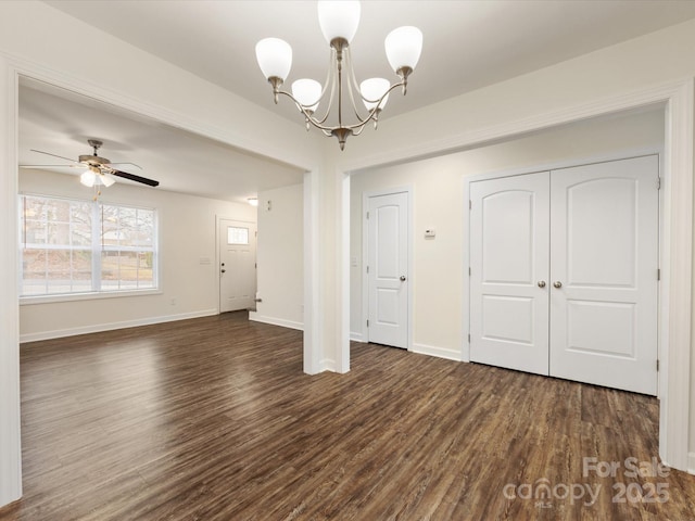 interior space featuring ceiling fan with notable chandelier and dark hardwood / wood-style flooring