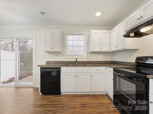 kitchen featuring dark stone counters, black appliances, sink, dark hardwood / wood-style flooring, and white cabinetry