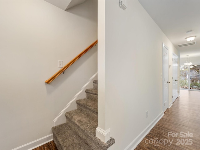 staircase featuring a notable chandelier and hardwood / wood-style flooring