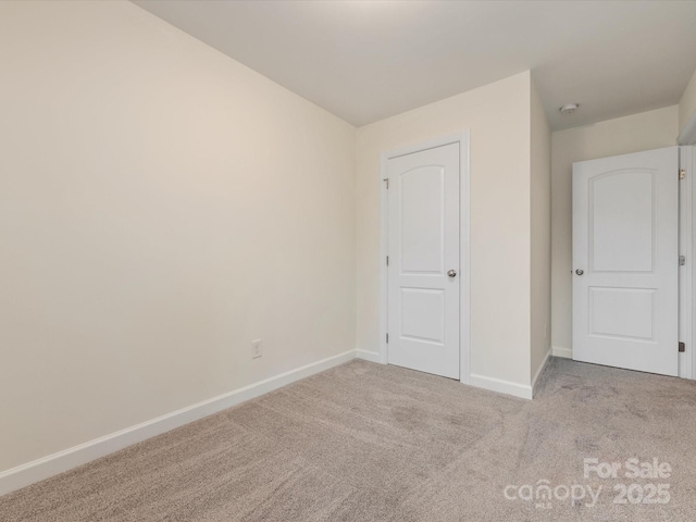 unfurnished bedroom with light colored carpet and a closet