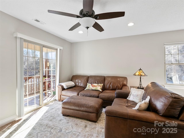 carpeted living room with ceiling fan