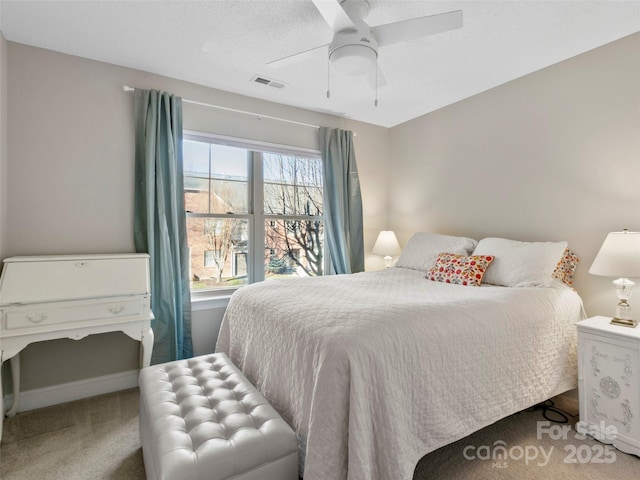 carpeted bedroom featuring multiple windows and ceiling fan